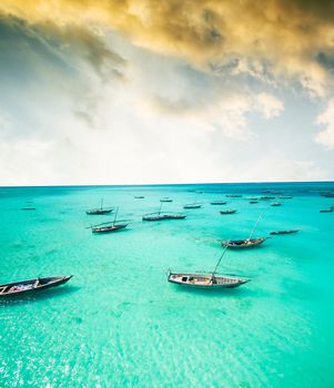 beautiful colorful seascape with african fishing boats in clear ocean, aerial photo