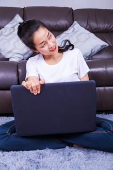 young beautiful woman using a laptop computer in living room at home