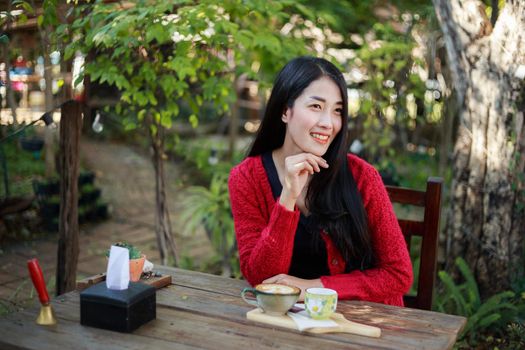 portrait of beautiful young woman with coffee in the garden