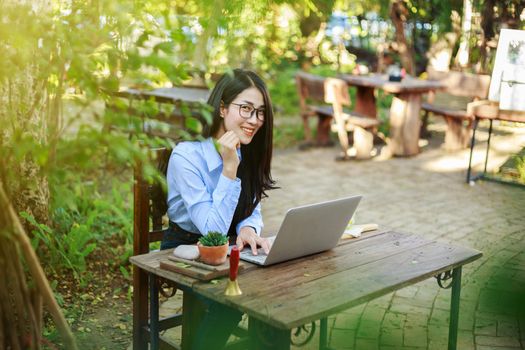 portrait of young woman with laptop and coffee in the garden