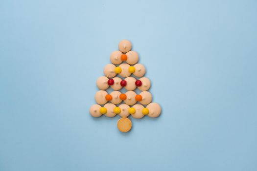 Christmas tree made of cookies and sweets on a blue background with space for text. Christmas baking concept