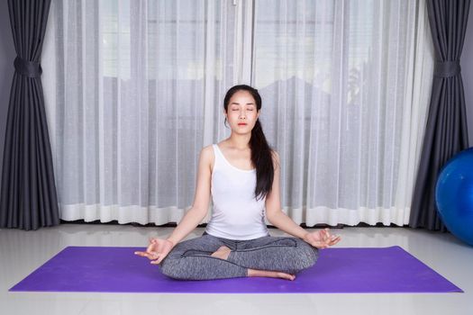 young woman doing yoga exercise isolated on a white background