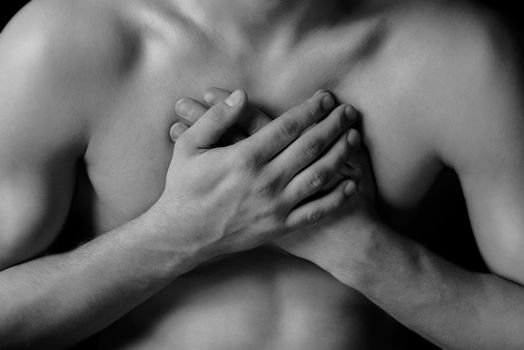Man is clutching his chest, acute pain possible heart attack, black and white image