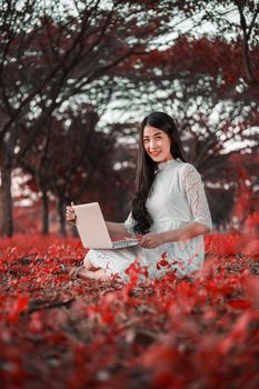 beautiful woman using laptop in the outdoor park