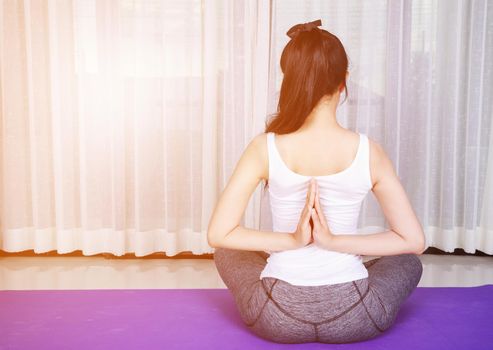 young woman doing yoga exercise isolated on a white background