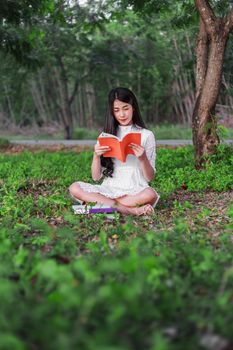 young woman reading a book in the park