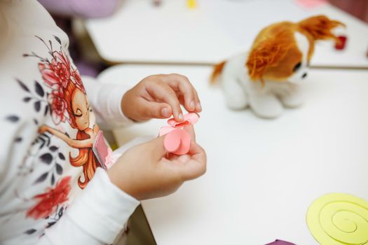 a child in training at home during quarantine makes origami out of paper. children's creativity. hands close up.