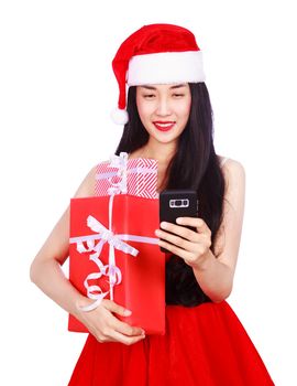woman in Santa Claus clothes looking at mobile phone with gift box isolated on a white background