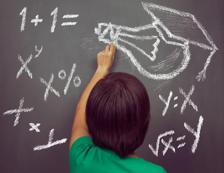 Unrecognizable woman is drawing lightbulb and formulas on the blackboard, concept of education