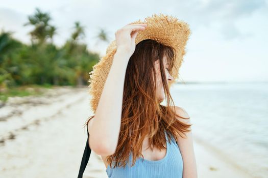 cheerful woman in a beach hat by the ocean island summer. High quality photo