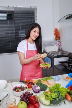 woman preparing a sandwich in kitchen room at home