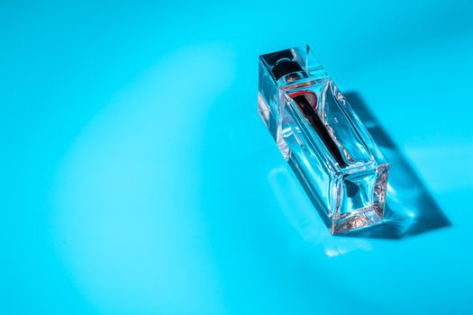 perfume glass bottle on light blue background. Eau de toilette