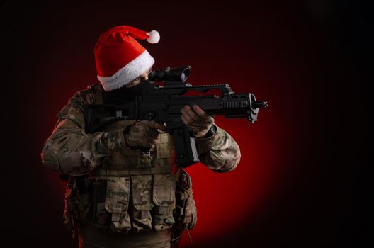 the man in a military uniform with a gun and a Santa Claus hat