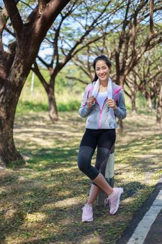 young sporty woman with white towel resting after workout sport exercises outdoors at the park