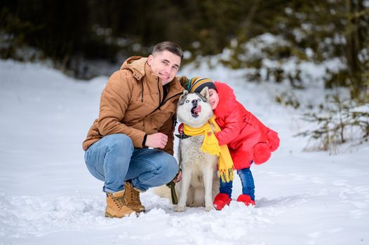 Happy father and little daughter and husky dog in winter forest walking in winter.new