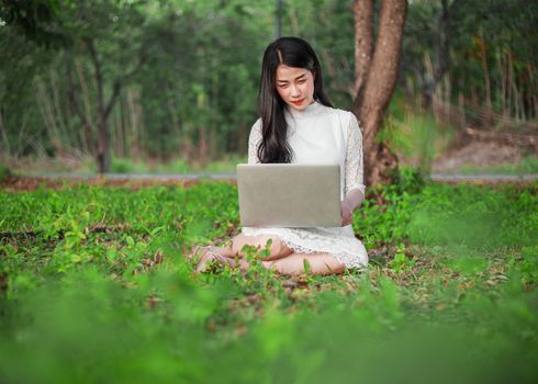 beautiful woman using laptop in the outdoor park