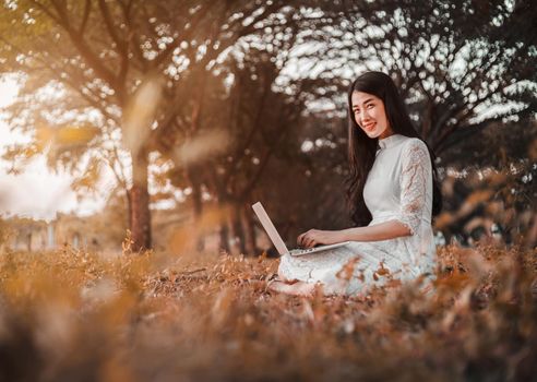 beautiful woman using laptop in the outdoor park