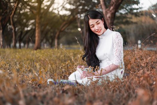 young woman reading a book in the park