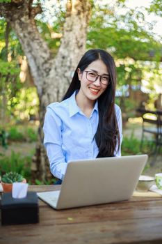 portrait of young woman with laptop and coffee in the garden