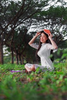 young woman holding a book in the park