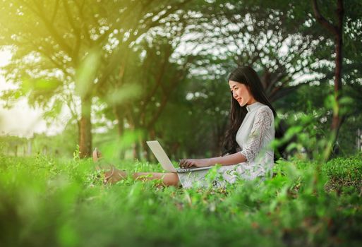 beautiful woman using laptop in the outdoor park