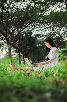 beautiful woman using laptop in the outdoor park