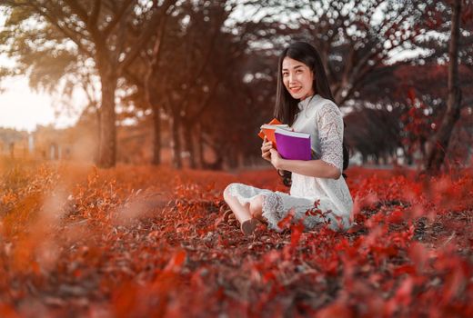 young woman holding a book in the park