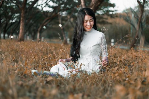 young woman reading a book in the park