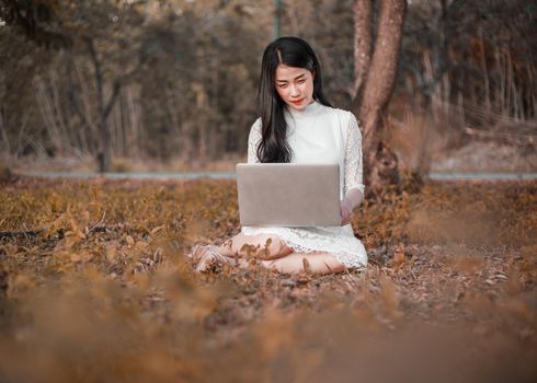 beautiful woman using laptop in the outdoor park