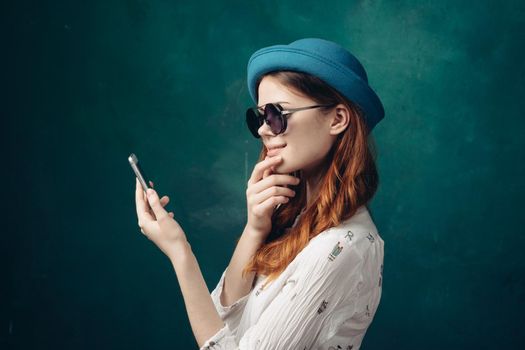 fashionable woman in blue hat with phone in hands communication technology. High quality photo