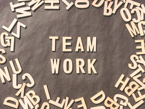 Team Work Word In Wooden Cube Alphabet Letters Top View On A rustic paper Background.