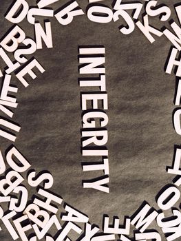 Integrity Word In Wooden Cube Alphabet Letters Top View On A rustic paper Background.