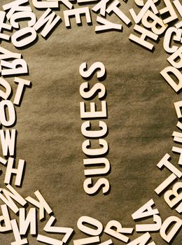 Success Word In Wooden Cube Alphabet Letters Top View On A rustic paper Background.