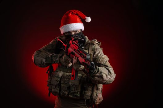 the man in a military uniform with a gun and a Santa Claus hat