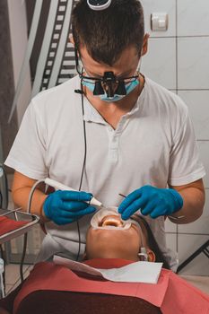 The dentist removes tartar using ultrasound, the patient at the dentist.2020