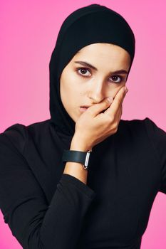 muslim woman with smart watch technology gadget pink background. High quality photo