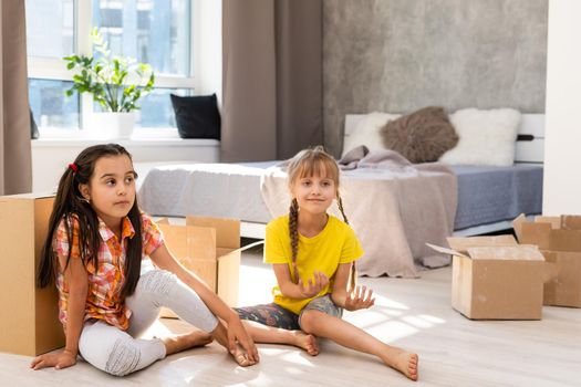 Excited funny kids girls running inside luxury big modern house on moving day, cute children entering exploring new home, happy young family buying real estate