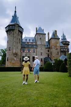 Castle de Haar Utrecht, couple men and woman mid age European and Asian visit De Haar Castle in Dutch Kasteel de Haar is located in Utrecht Netherlands during Spring with flowers in the garden