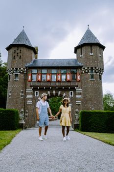 Castle de Haar Utrecht, couple men and woman mid age European and Asian visit De Haar Castle in Dutch Kasteel de Haar is located in Utrecht Netherlands during Spring with flowers in the garden