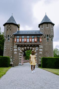 Castle de Haar Utrecht, couple men and woman mid age Asian visit De Haar Castle in Dutch Kasteel de Haar is located in Utrecht Netherlands during Spring with flowers in the garden