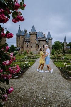 Castle de Haar Utrecht, couple men and woman mid age European and Asian visit De Haar Castle in Dutch Kasteel de Haar is located in Utrecht Netherlands during Spring with flowers in the garden