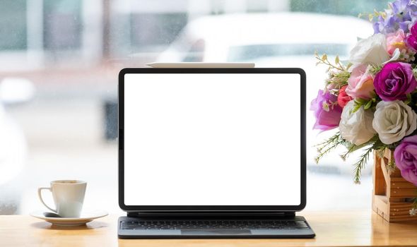 Digital tablet with blank white screen on workplace at cafe.