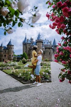 Castle de Haar Utrecht, couple men and woman mid age European and Asian visit De Haar Castle in Dutch Kasteel de Haar is located in Utrecht Netherlands during Spring with flowers in the garden