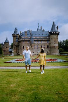 Castle de Haar Utrecht, couple men and woman mid age European and Asian visit De Haar Castle in Dutch Kasteel de Haar is located in Utrecht Netherlands during Spring with flowers in the garden