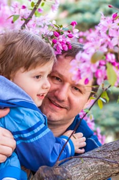 A male father spends time with his young son. Family walks in nature. The joy of being together.