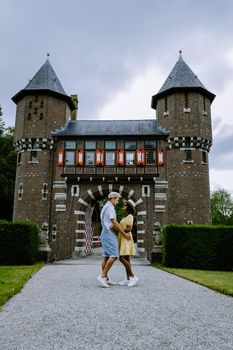 Castle de Haar Utrecht, couple men and woman mid age European and Asian visit De Haar Castle in Dutch Kasteel de Haar is located in Utrecht Netherlands during Spring with flowers in the garden