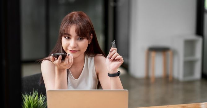 Portrait young asian woman contact with credit card call centre service, woman making phone call while holding credit card, online shopping payment.