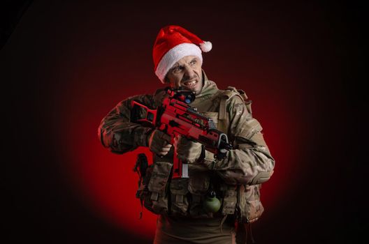 the man in a military uniform with a gun and a Santa Claus hat