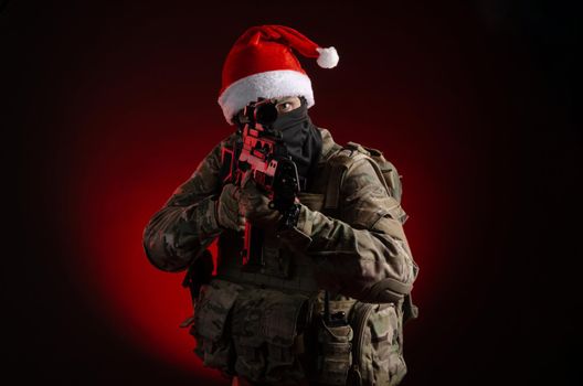 the man in a military uniform with a gun and a Santa Claus hat