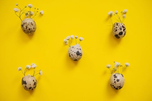 Easter background, quail eggs on a yellow background, decorated with natural botanical elements, flat lay, view from above